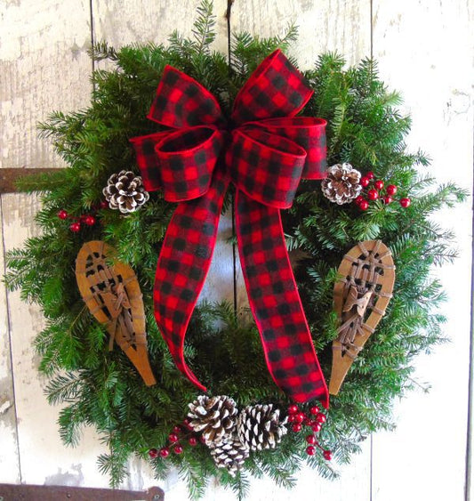 A wreath with a red and black ribbon