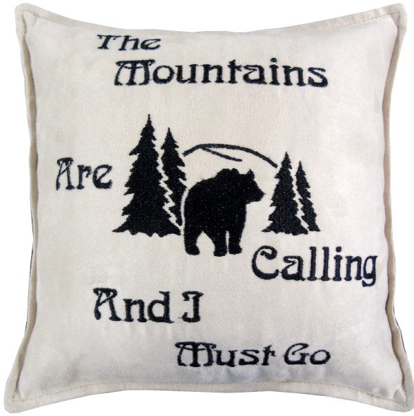 White pillow with a bear design and text “The mountains are calling and I must go”